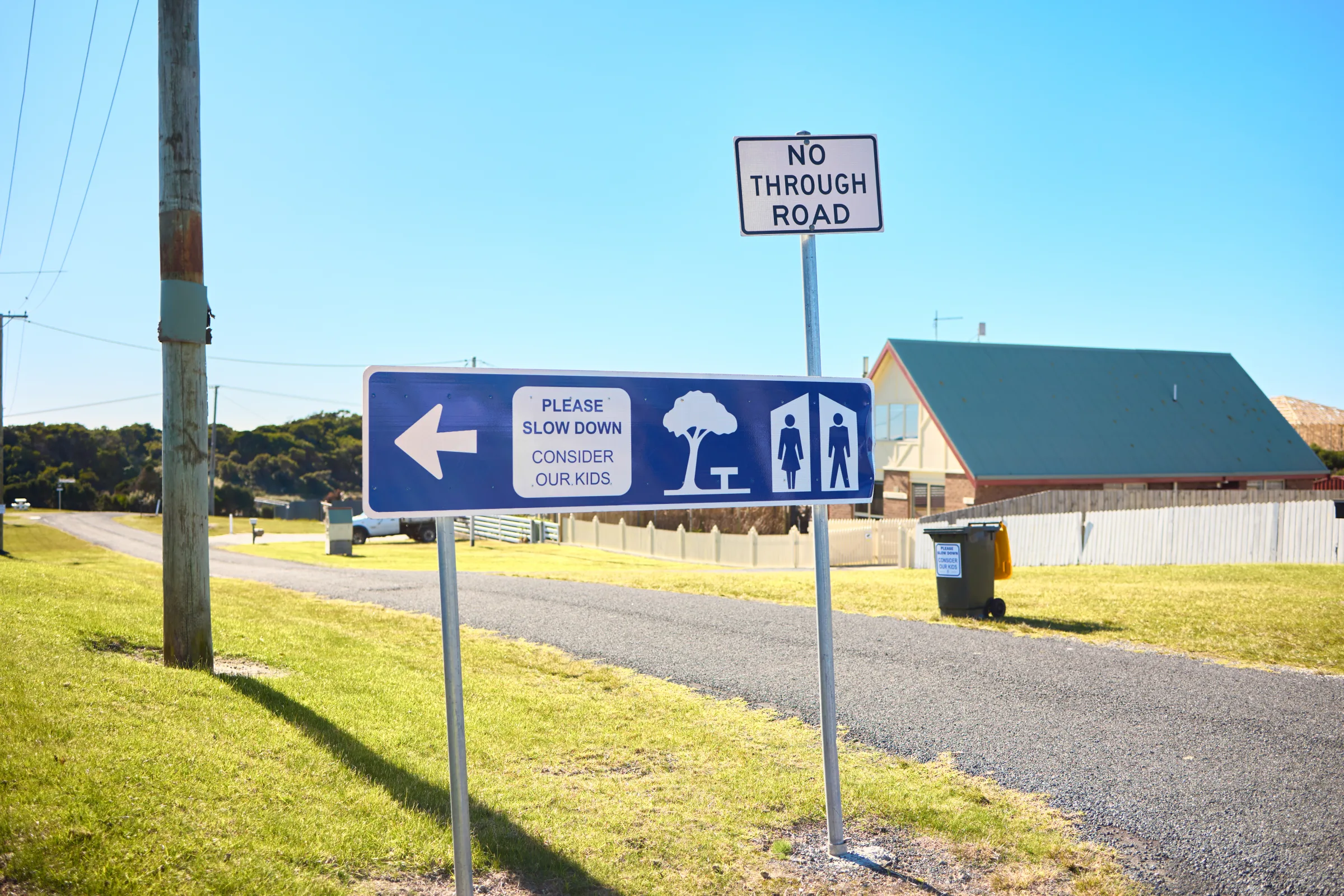 A no through road sign and a please slow down, consider our kids sign on the quiet street